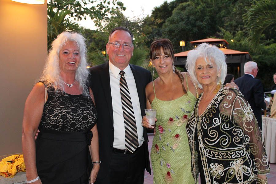 Four people at an outdoor event: two women on either side and in the middle, a man and another woman.
