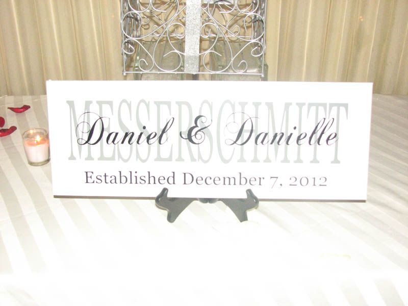 White sign with couple's names and wedding date 