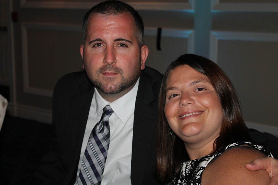 Man and woman smiling, formal attire, indoors.
