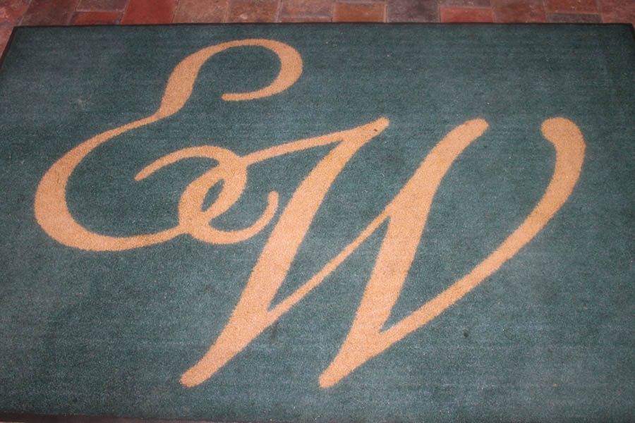 Green welcome mat with tan cursive 