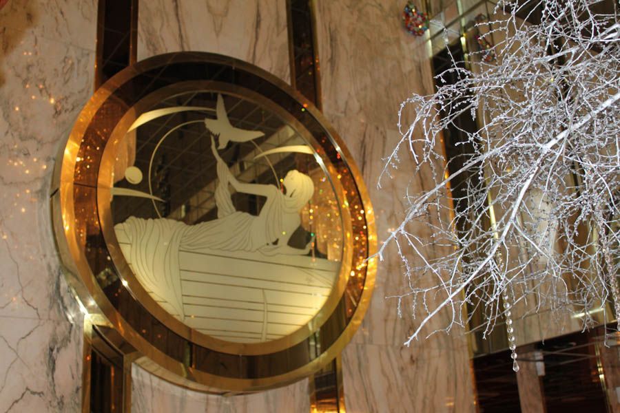 Circular art deco mirror: engraved boat scene, golden frame, white branches.