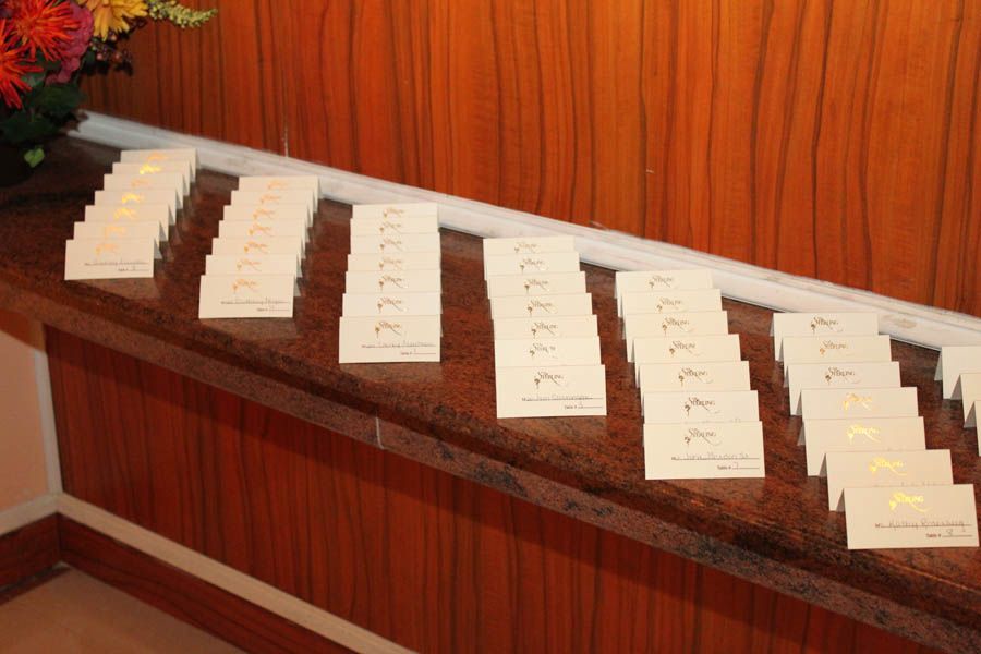 Stacks of name cards with gold accents arranged on a wood-paneled surface.