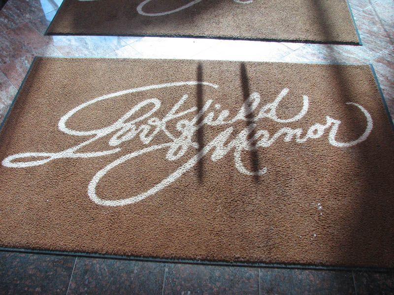 Brown doormat with white cursive text reading 