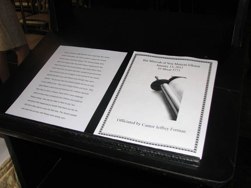 Two documents on a black surface. One with text, the other with title 