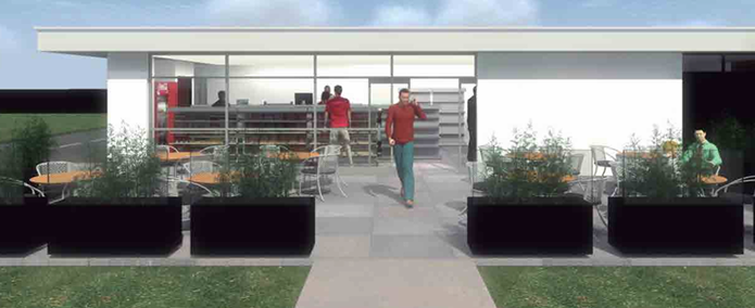 Obrero de la construcción con arnés aplicando estuco a la pared de ladrillo de un edificio.