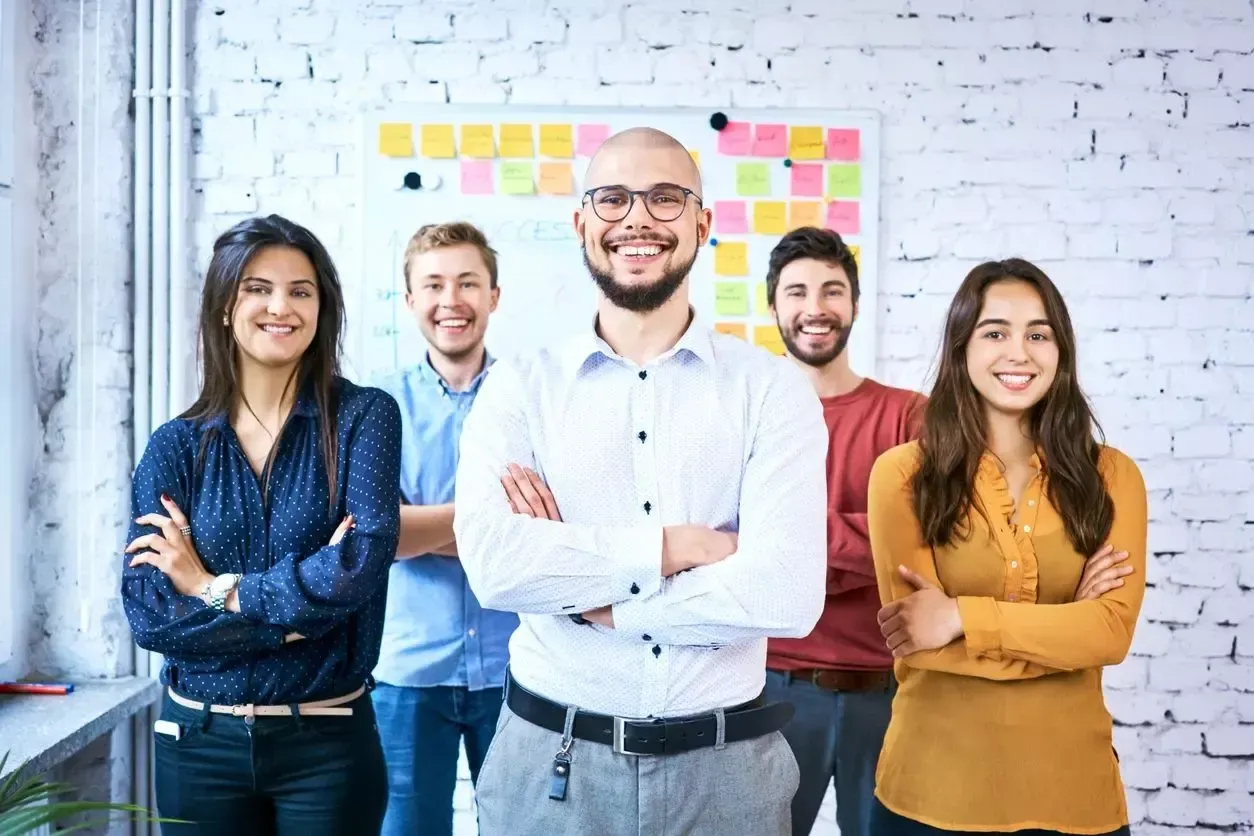 A group of people standing next to each other with their arms crossed.
