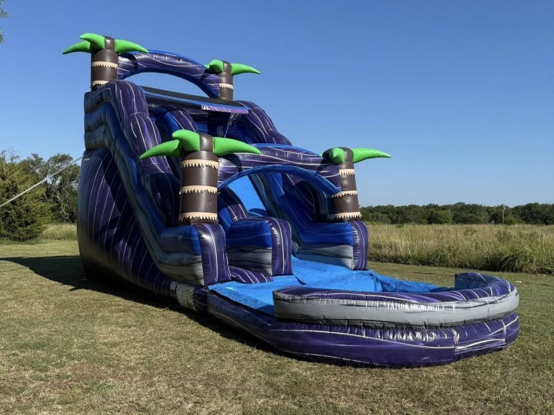 Colorful inflatable bounce slide on a grassy yard beside a brick house under a cloudy sky