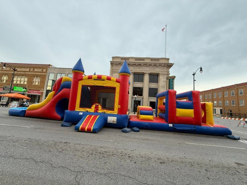 Colorful inflatable bounce house on a city street in front of a historic building