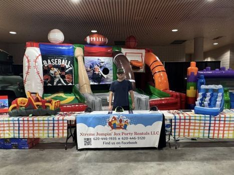 Indoor inflatable baseball batting game booth with colorful red, green, orange, and blue targets and a sign in front