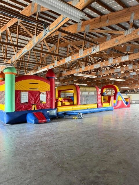 Colorful inflatable bounce house in a large wooden pavilion with an open concrete floor