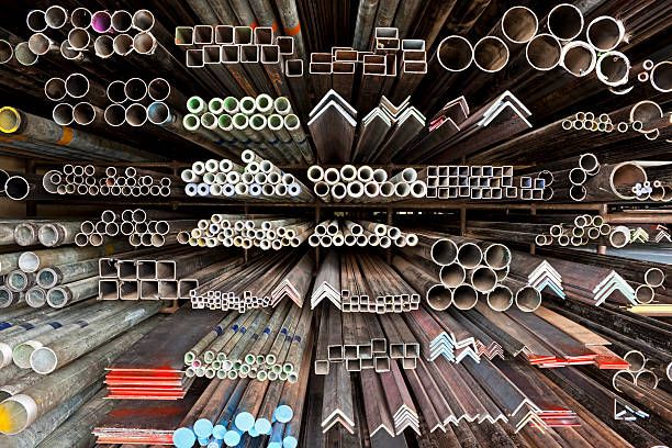 Shelves filled with various metal shapes, including pipes, angles, and squares in a hardware store.