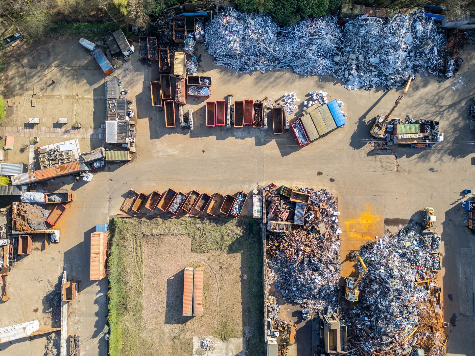 Scrap metal recycling yard with sorted ferrous and non-ferrous metals.