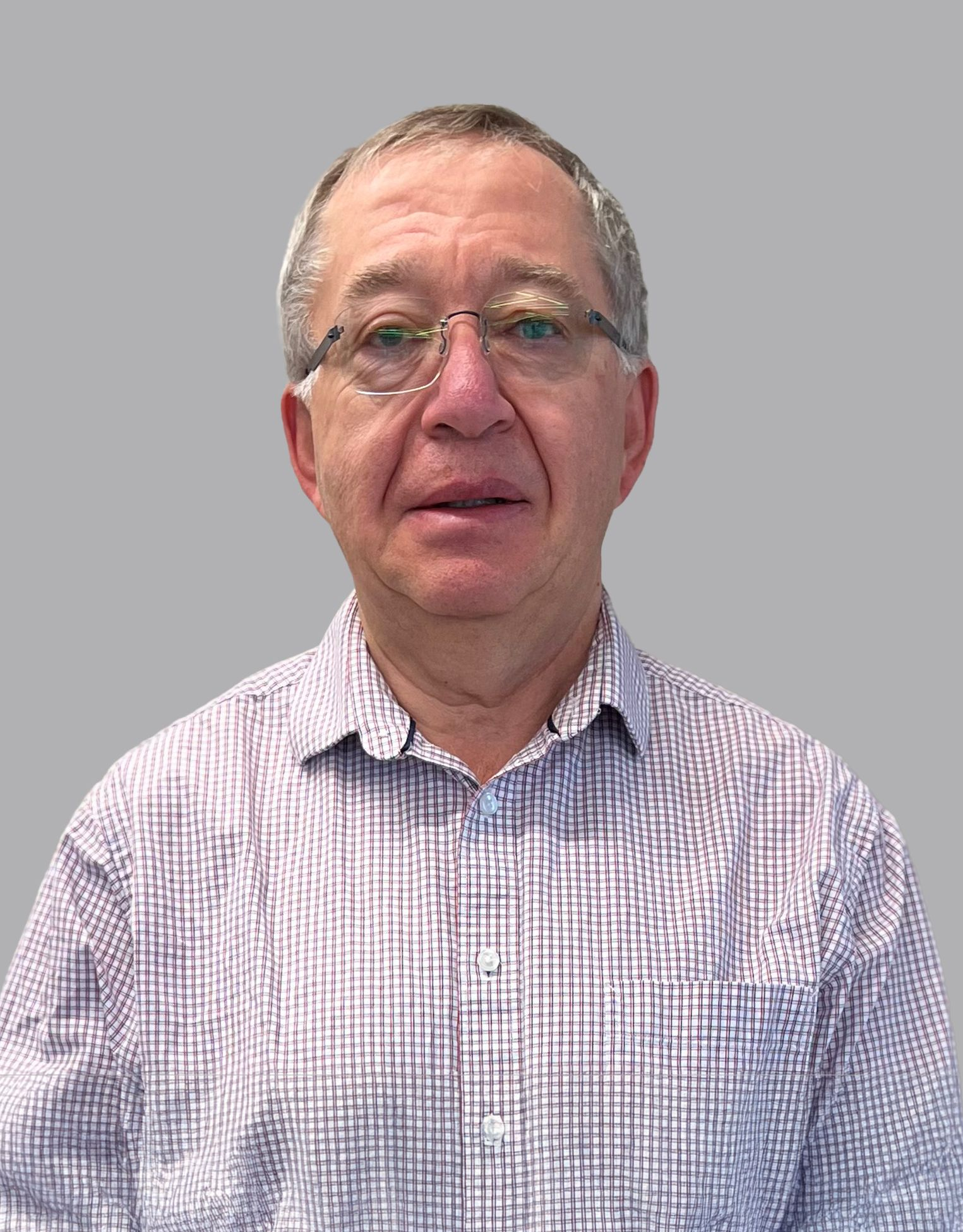 Man wearing glasses and a checkered shirt, facing forward against a plain gray background