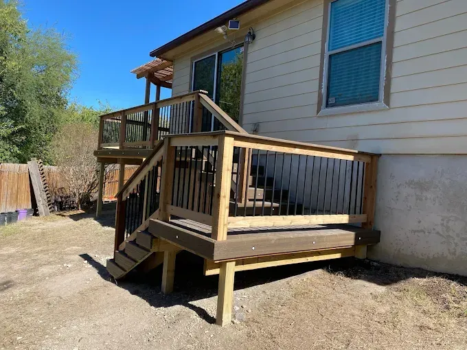 Wooden accessibility ramp and small deck attached to a beige house under a blue sky
