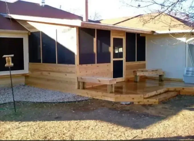 Small wooden house porch with steps and benches under a covered roof in a yard