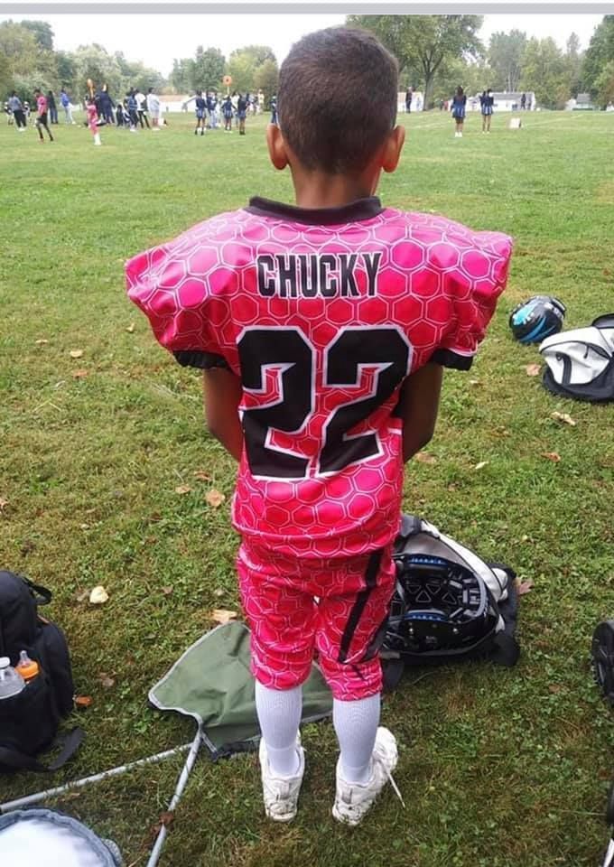 Young football player in pink jersey,