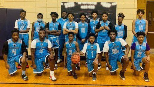Basketball team posing for a group photo in a gym, wearing light blue and black uniforms.