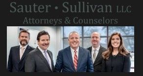 Sauter & Sullivan LLC attorneys: five professionals in suits, smiling in an office setting.