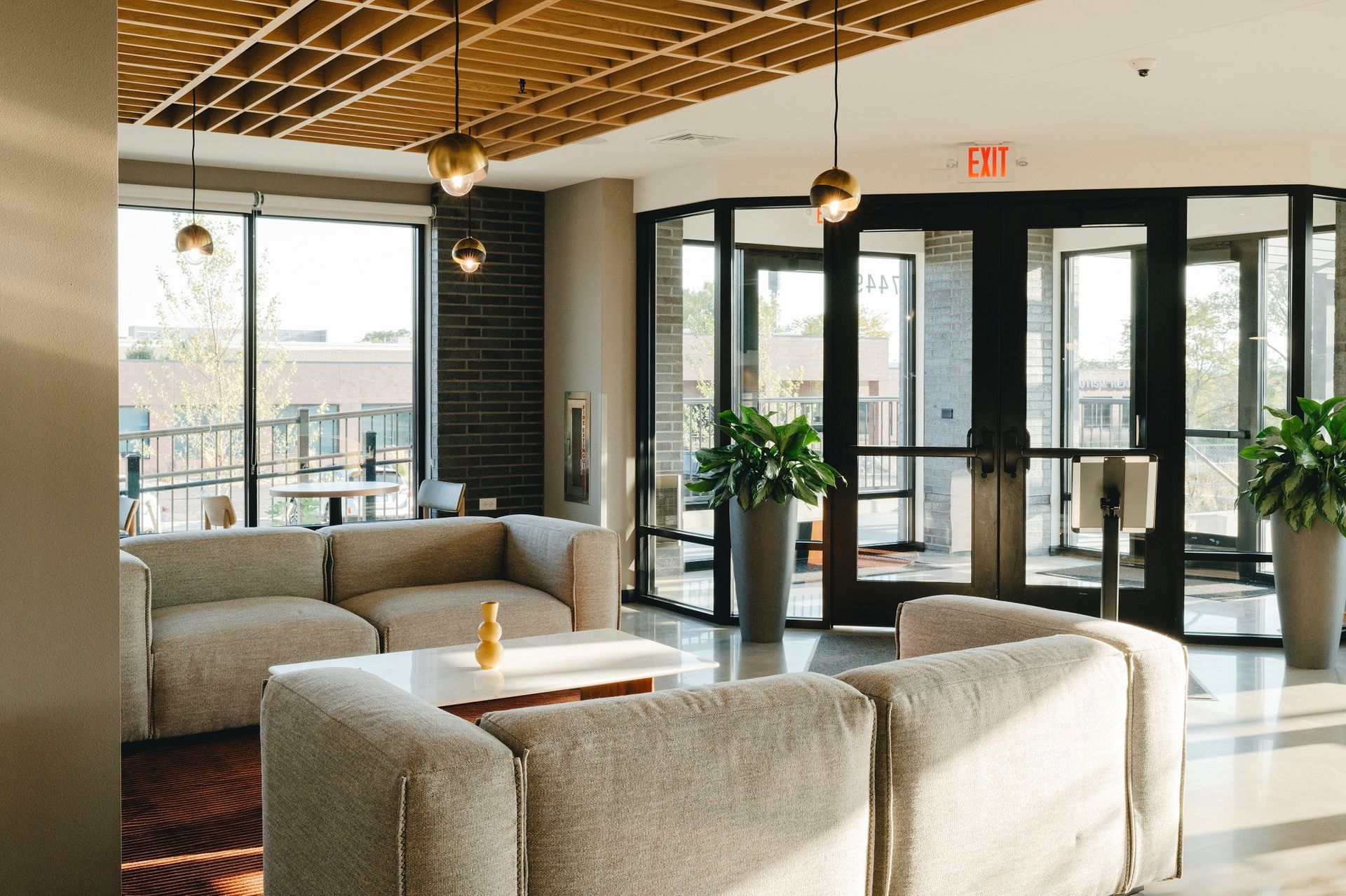 Cozy lounge area with sofas, a coffee table, and glass doors leading outside at Revelry in Madison, WI.