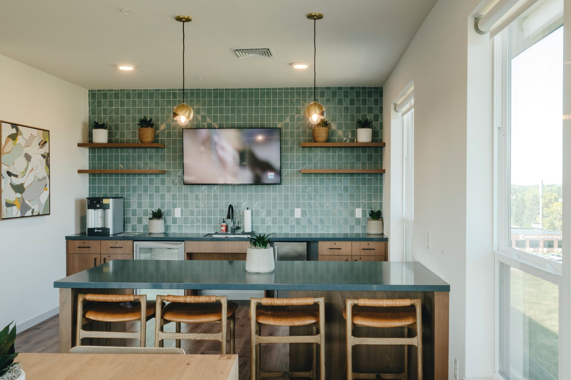 Kitchen with blue island, teal backsplash, wooden shelves, and bar seating at Revelry in Madison, WI.