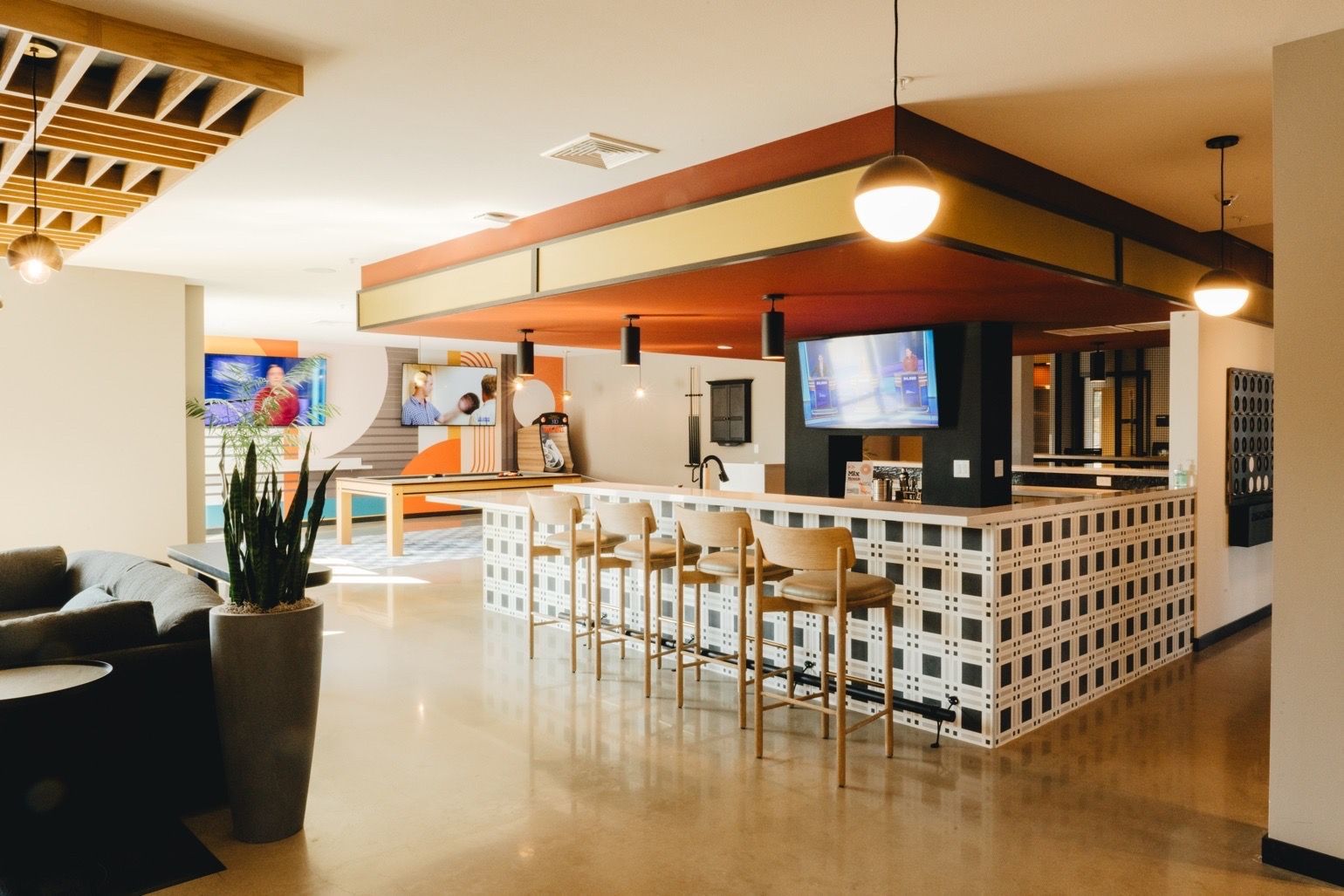 Bar with patterned tile front, wood stools, and a red and gold ceiling at Revelry in Madison, WI.