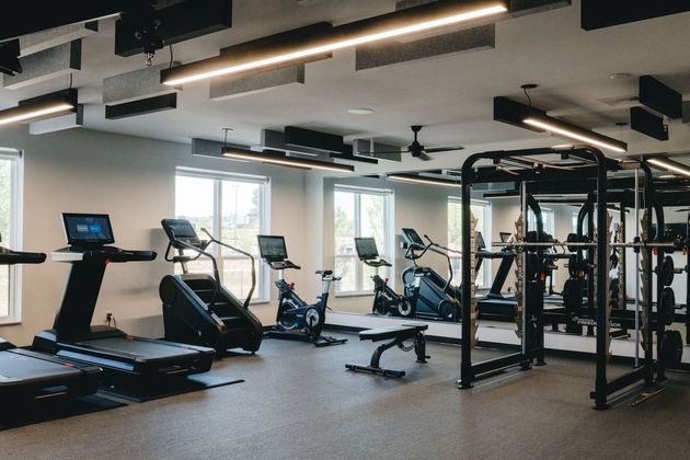 Gym interior with treadmills, stair climbers, exercise bikes, and weight machine near Greenway Station..