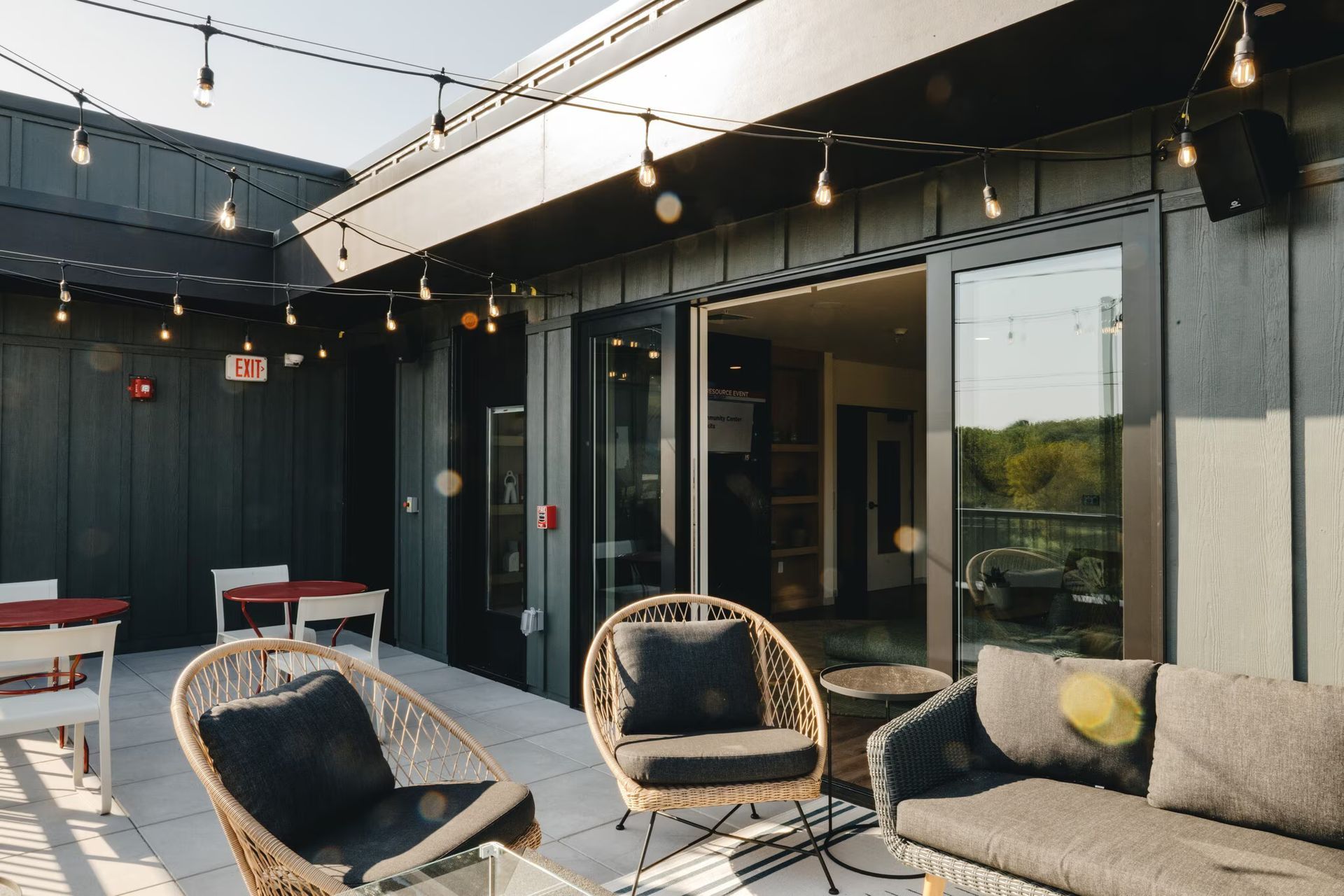 Rooftop patio with string lights, seating, and access to a building interior at Revelry in Madison, WI.