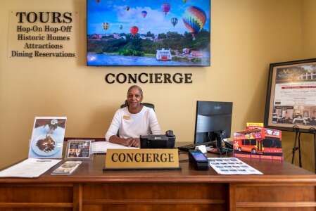 Concierge desk: woman in white shirt, behind a desk with 