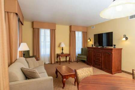 Living room with a beige sofa, TV, and dark wood furniture.