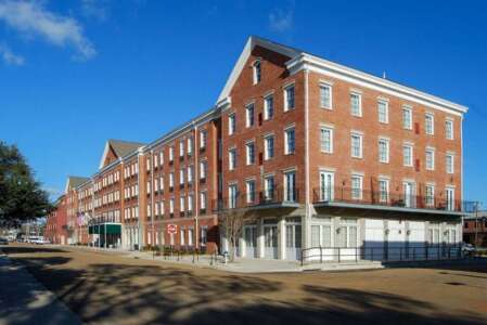 Brick building with windows and a white overhang on a sunny day.