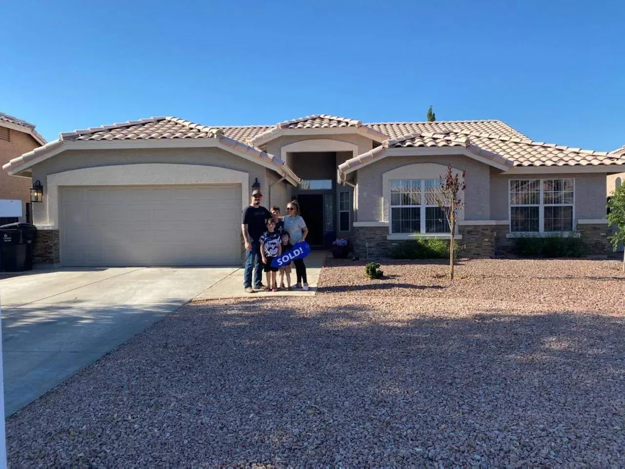 Family posing in front of their new home in Gilbert, AZ