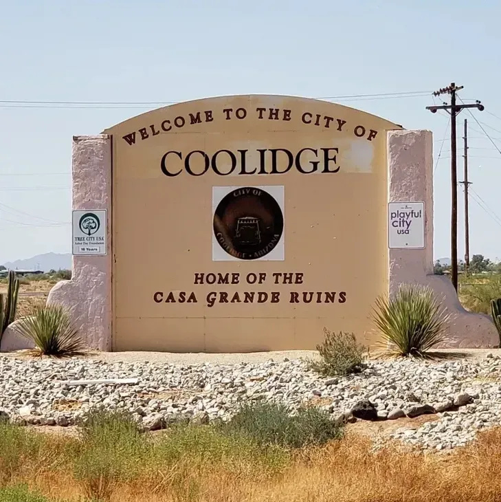 Welcome sign for Coolidge, Arizona, reading “Home of the Casa Grande Ruins” in a desert setting