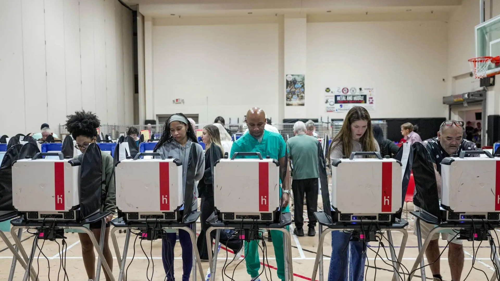 Diverse voters using electronic voting machines.
