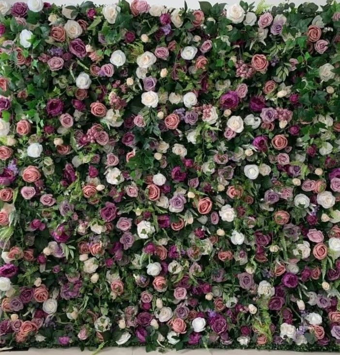 Dense floral wall of pink, white, and purple roses and greenery