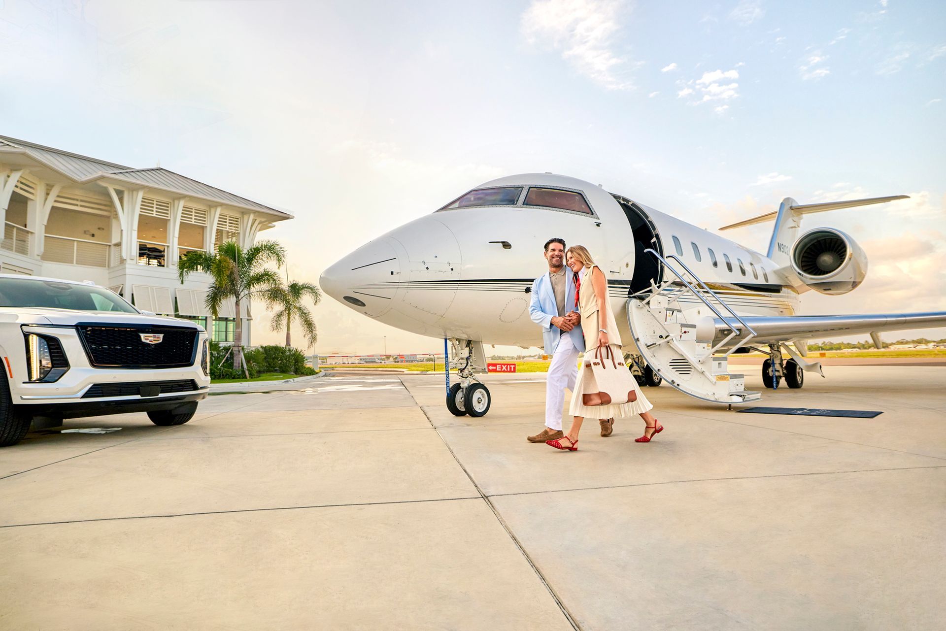 Couple walking to a waiting car beside a luxury private aircraft, photographed by George Kamper.