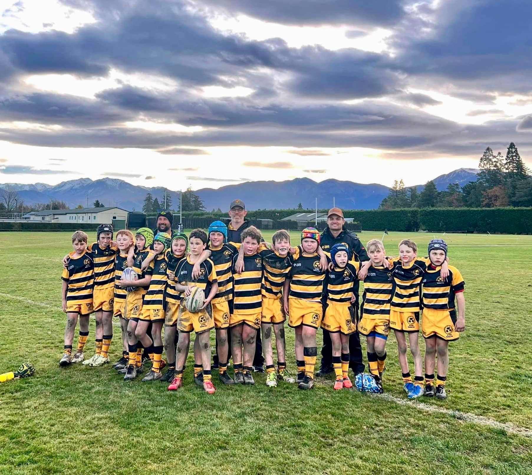 A group of young boys are posing for a picture on a field