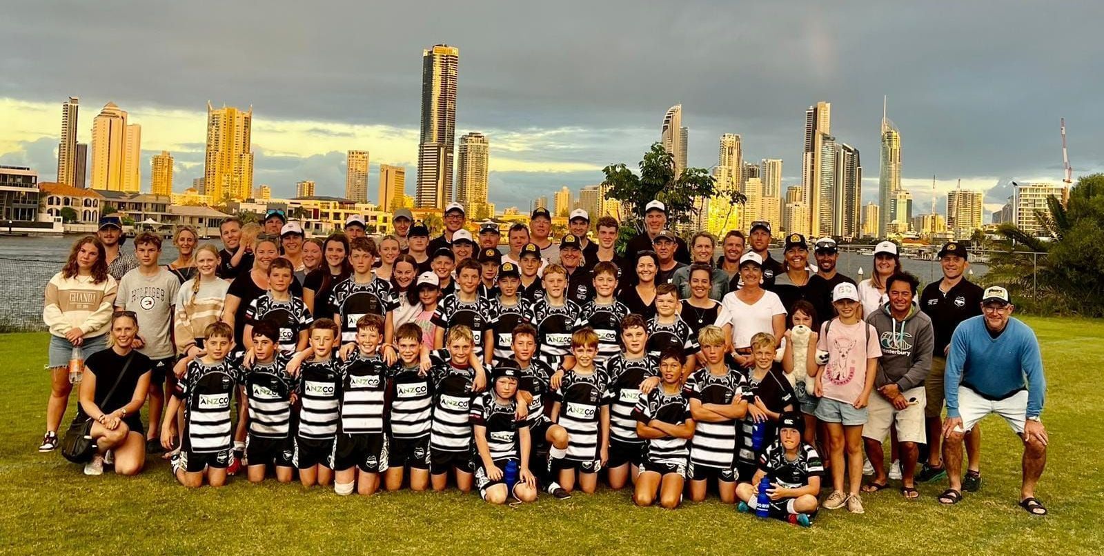 A large group of people are posing for a picture in front of a city skyline