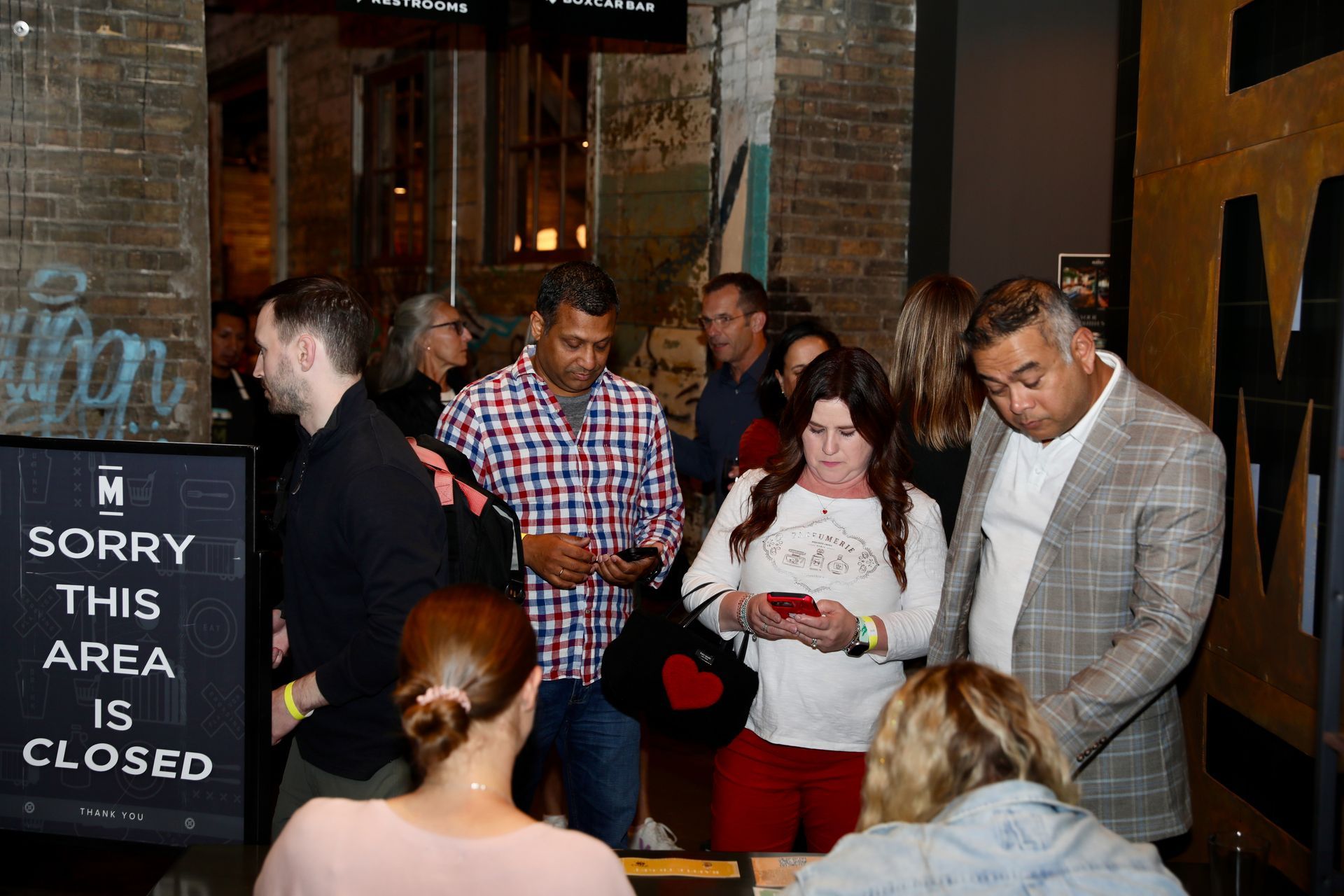 People standing near a doorway. A sign reads 
