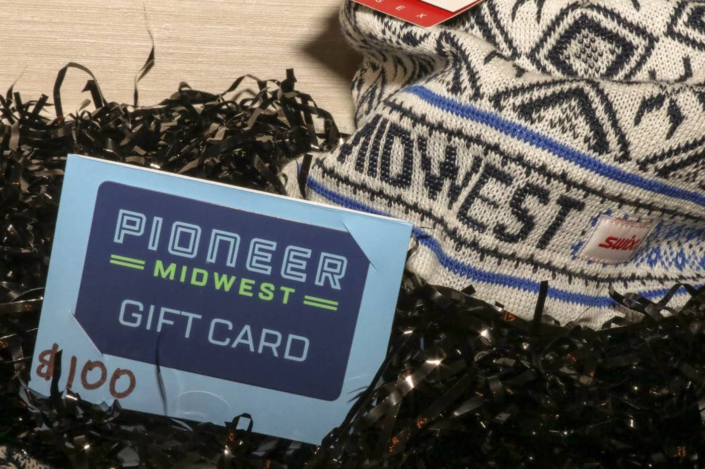 Pioneer Midwest gift card ($100) next to black/white knit hat with blue trim, in black filler.
