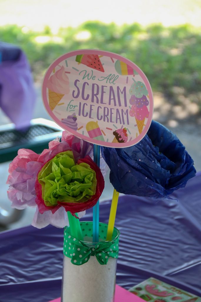 A handmade ice cream-themed centerpiece with paper flowers and a sign that reads 