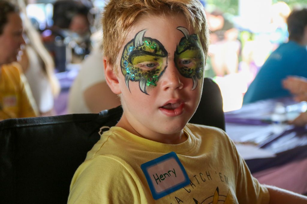 Boy with dragon eye face paint and name tag that says 