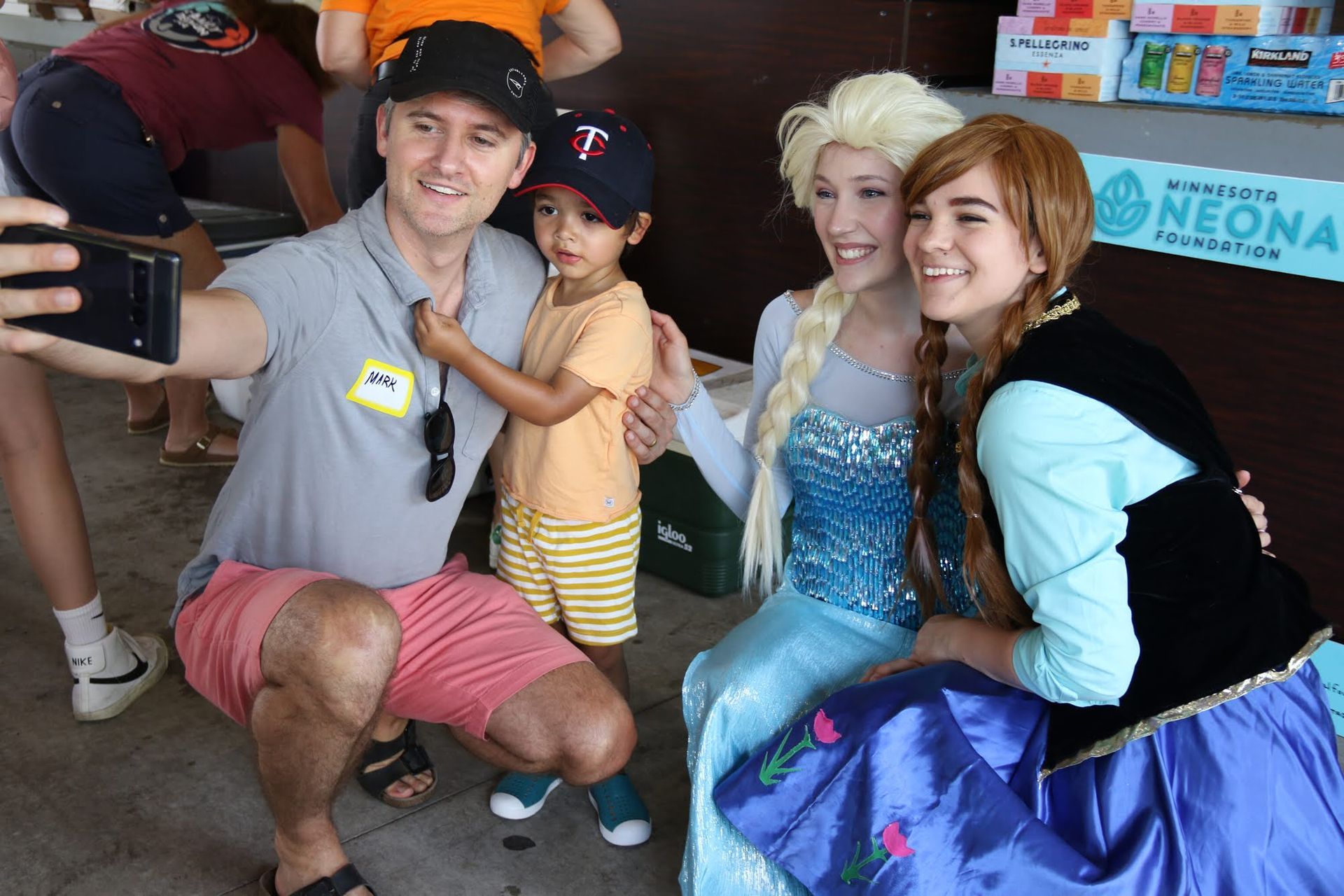 Man and child take selfie with Elsa and Anna from Frozen.