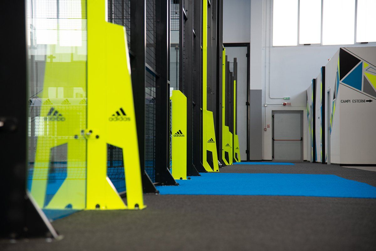 Percorso a ostacoli giallo e nero con logo Adidas, al chiuso.