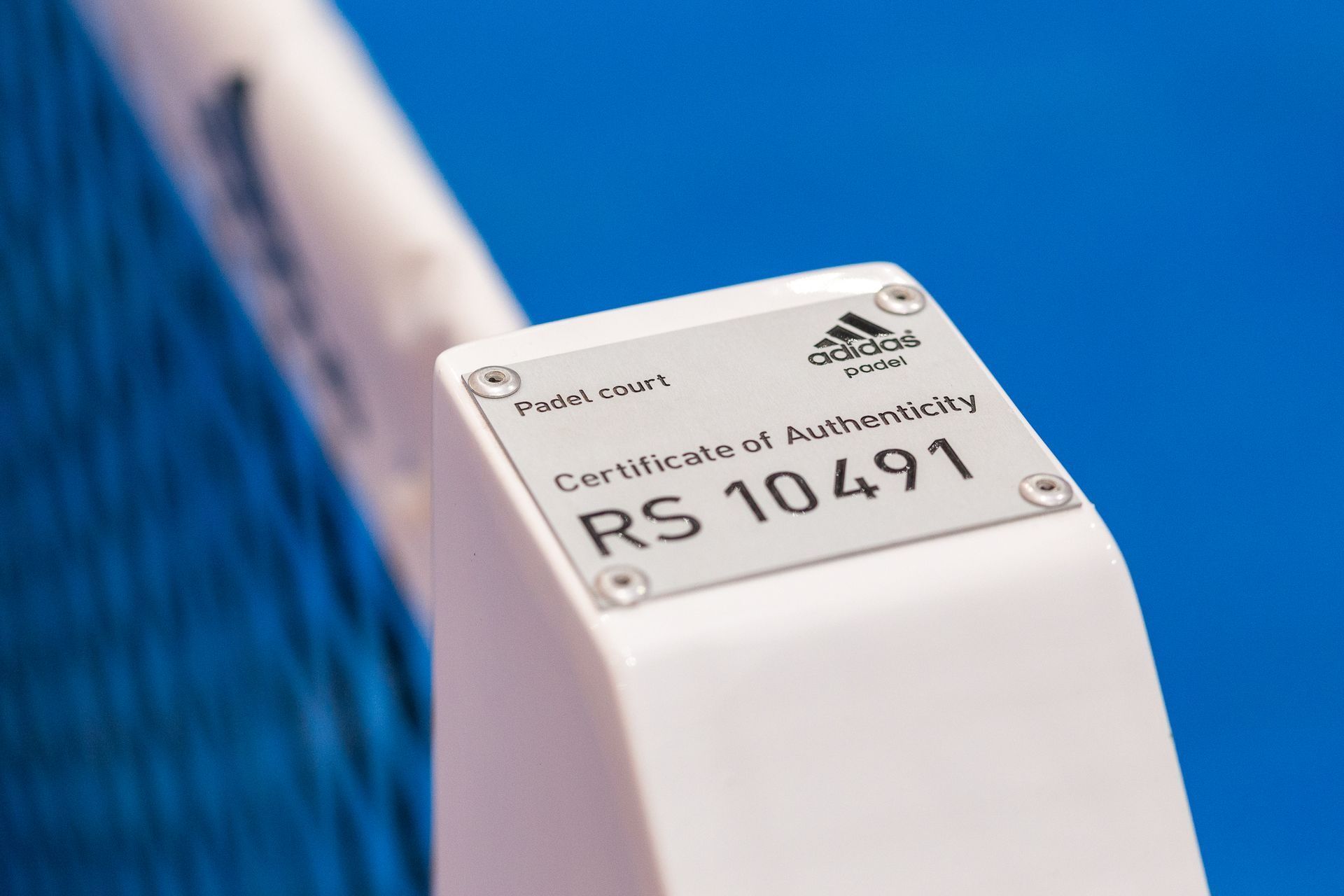 Primo piano di un'etichetta Adidas nano bianca con la scritta "Certificato di autenticità" e il numero di serie RS 10491.