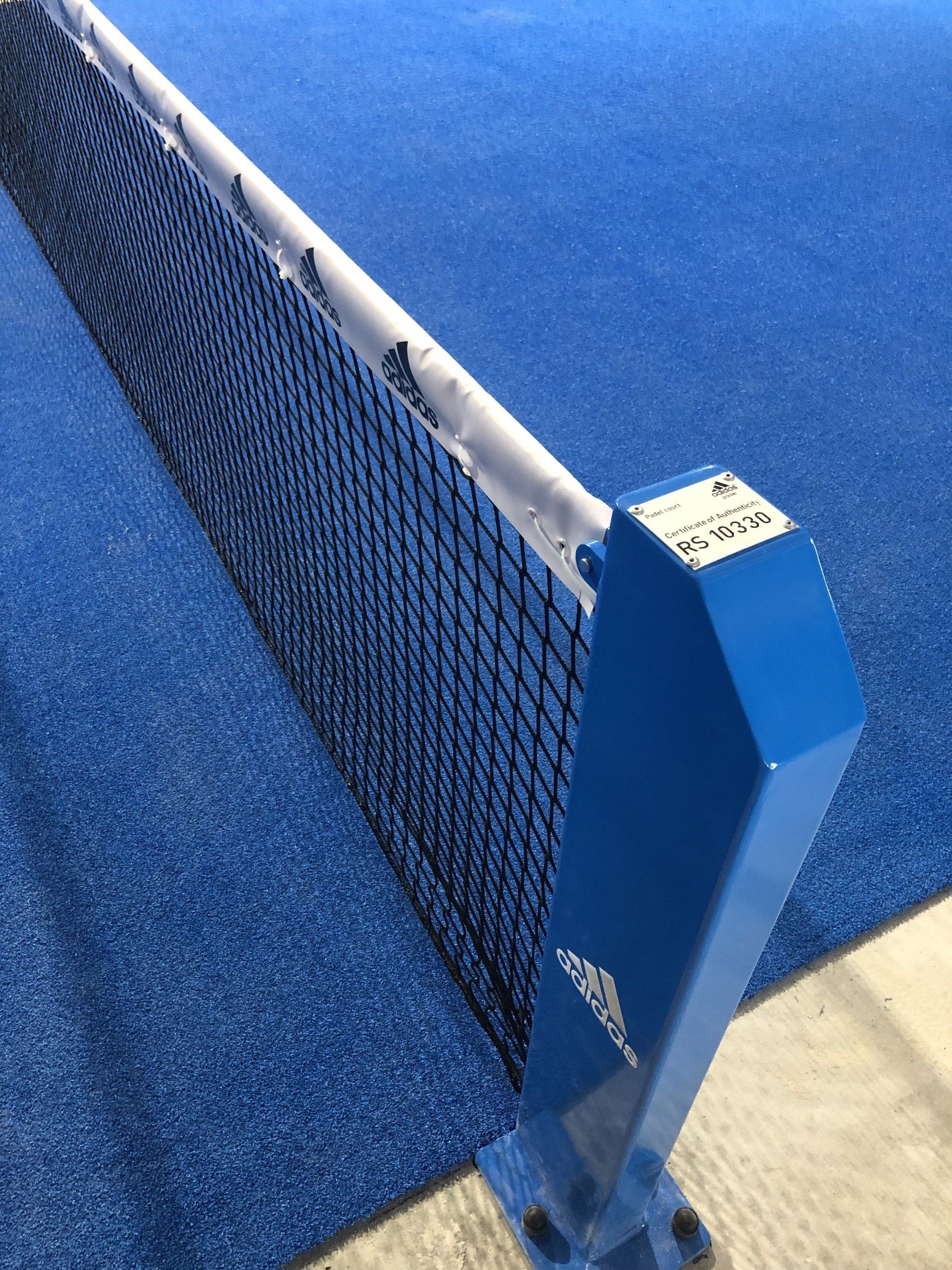 Rete da padel tennis blu e palo su un campo blu.