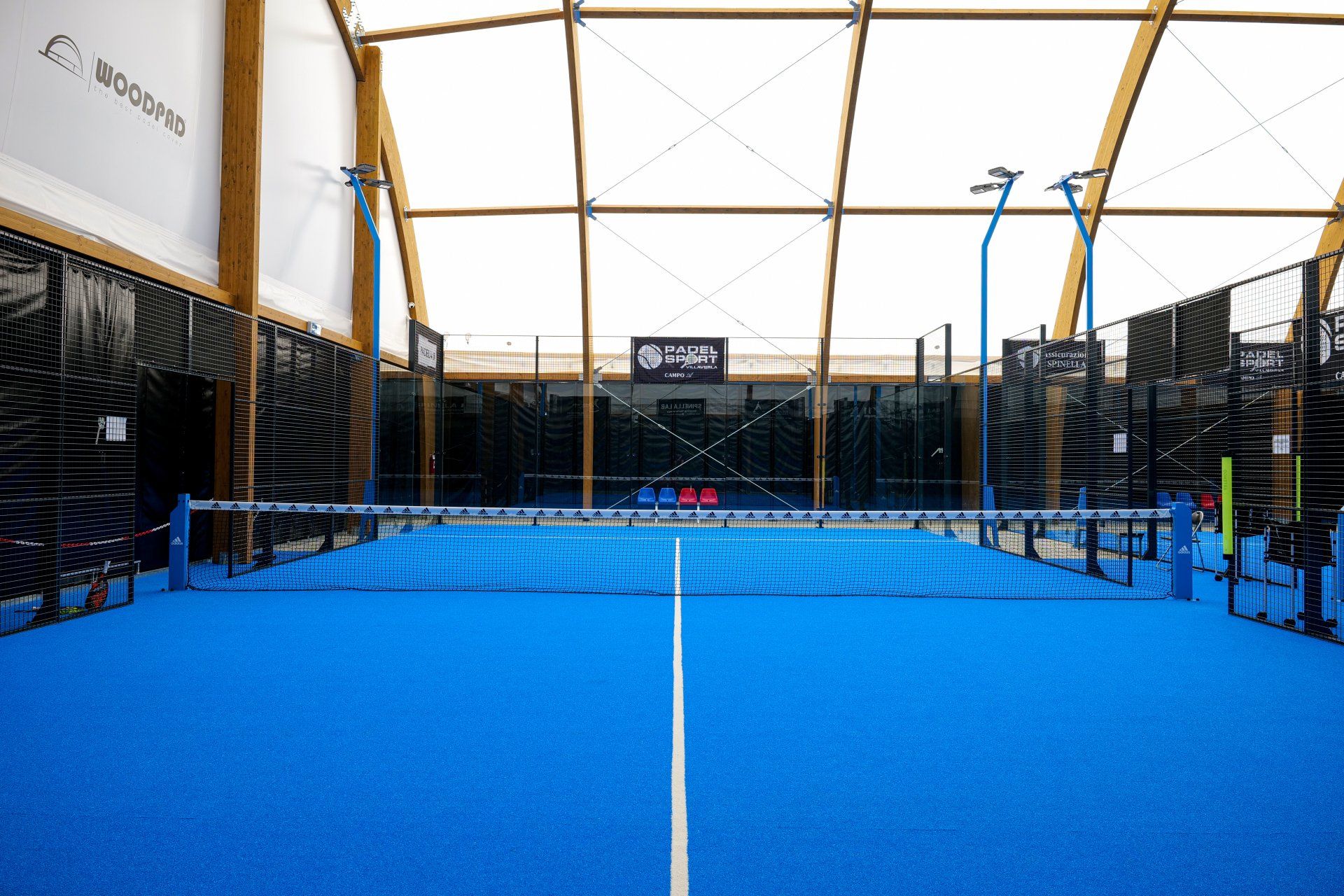 Campo da padel blu coperto con rete e coperto.