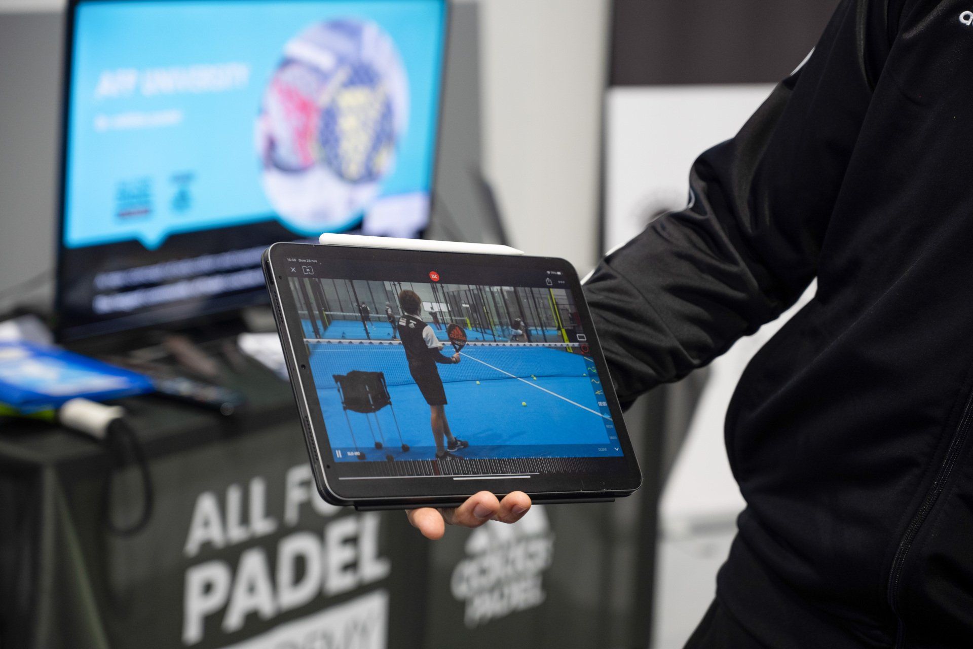 Persona che tiene in mano un tablet che mostra lo swing di un giocatore di padel; 