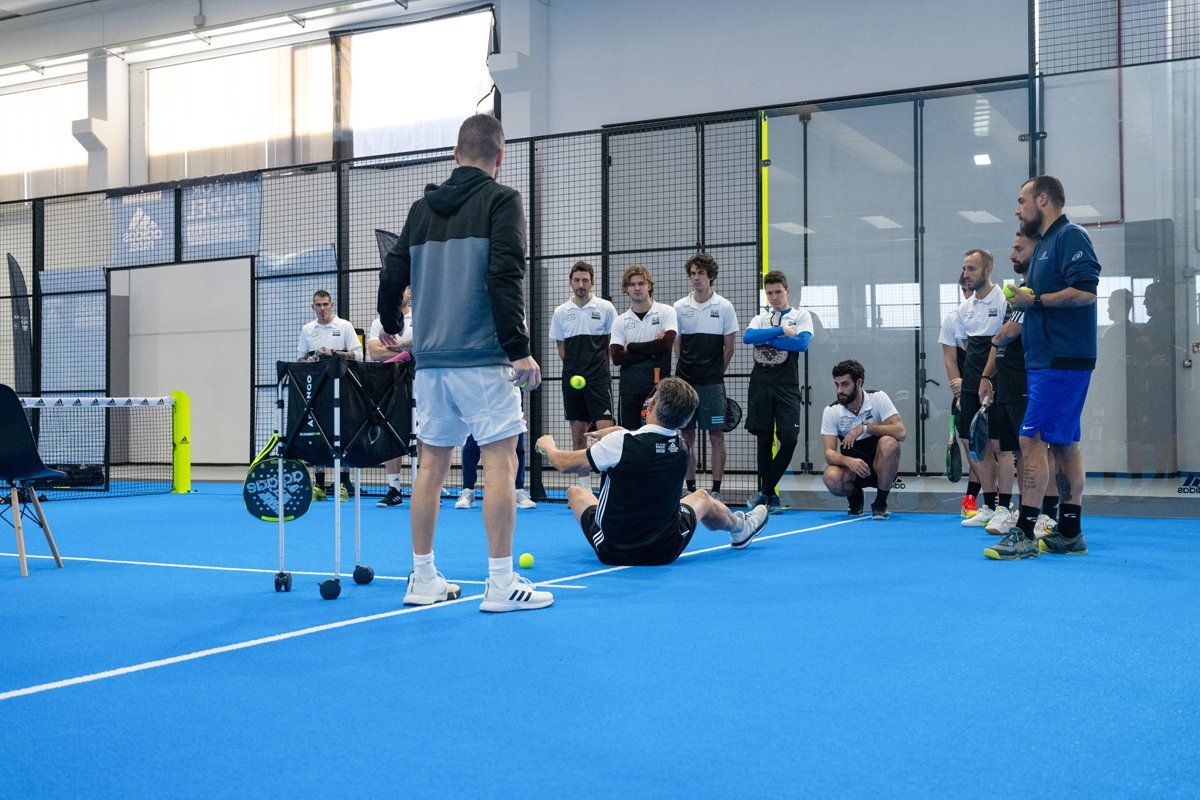 Sessione di allenamento di padel su un campo. L'allenatore impartisce istruzioni ai giocatori