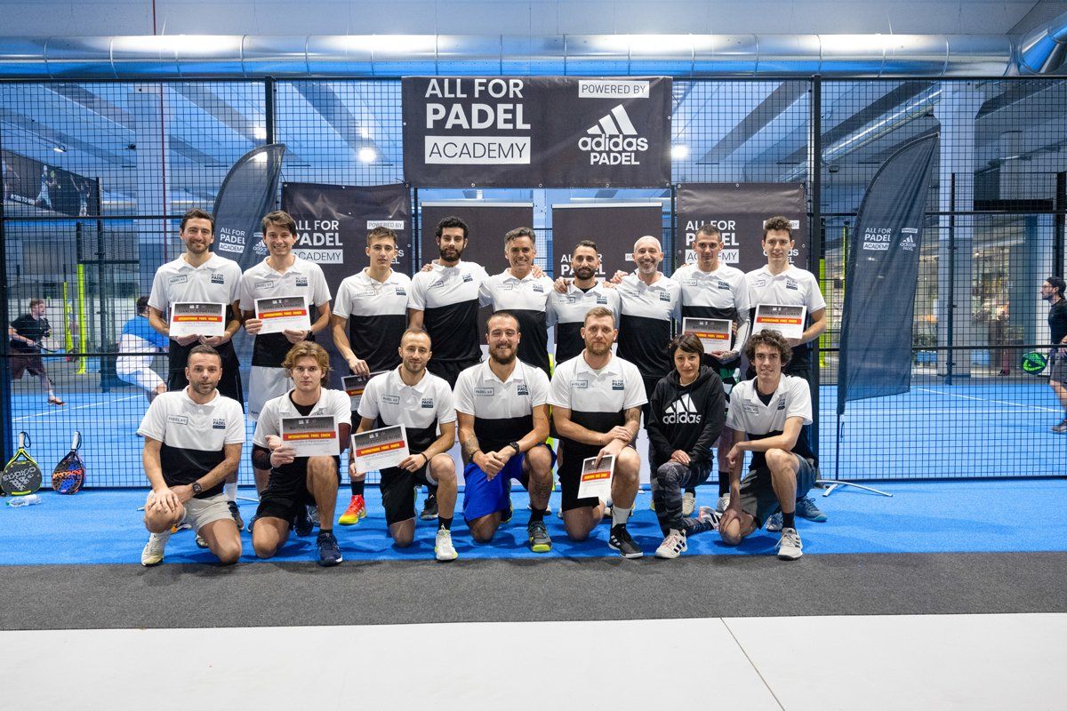 Gruppo di persone in abbigliamento sportivo, con attestati in mano, in posa su un campo da padel,