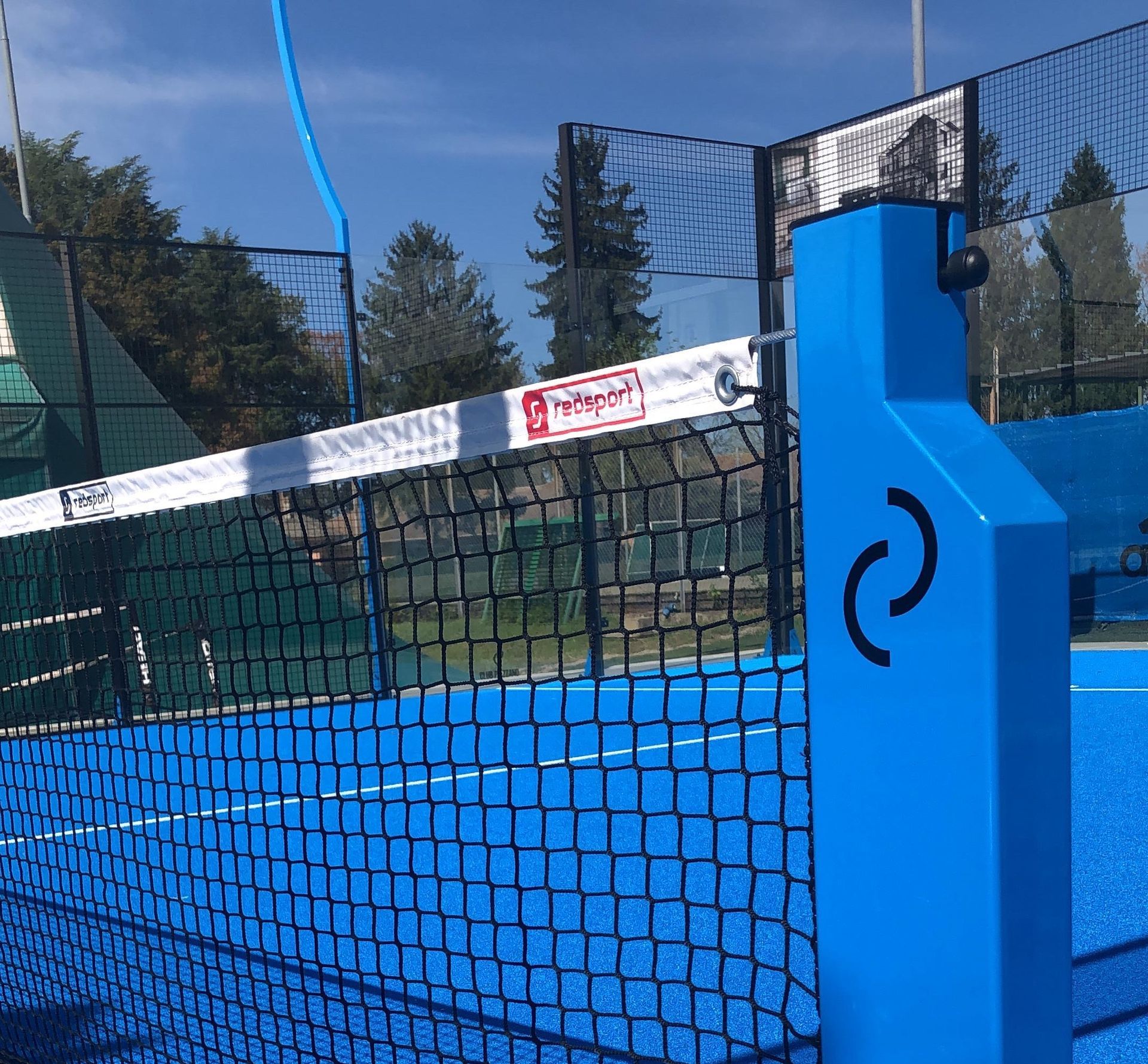 Rete e palo da padel blu con rete nera, installazione all'aperto.
